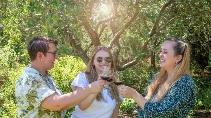 Three people enjoying a glass of wine in the Mediterranean Garden at Kew