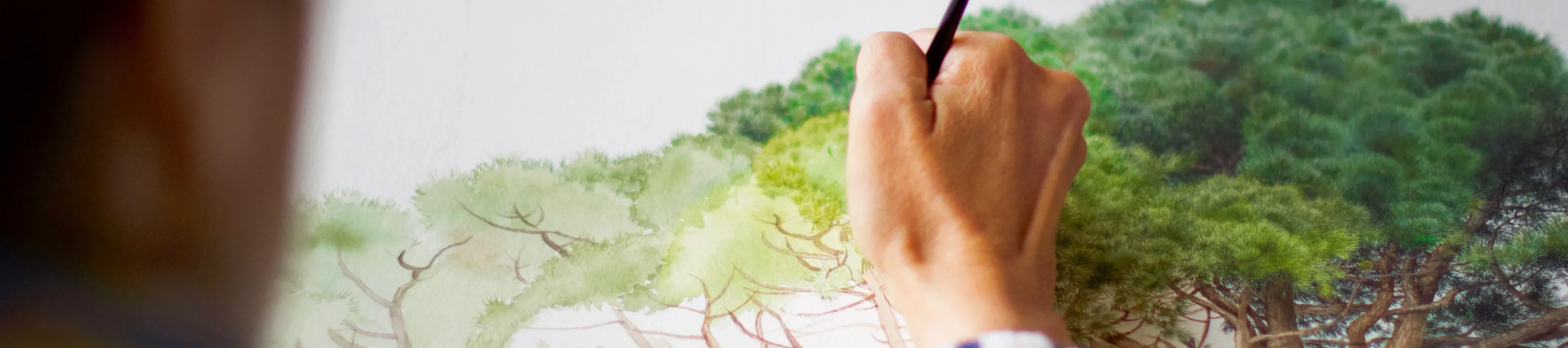 Close up of artist painting a tree on paper