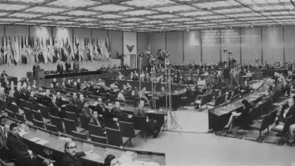 A black and white photo shows a huge conference room in Washington D.C. people have hairstyles and dress typical of the 1970s