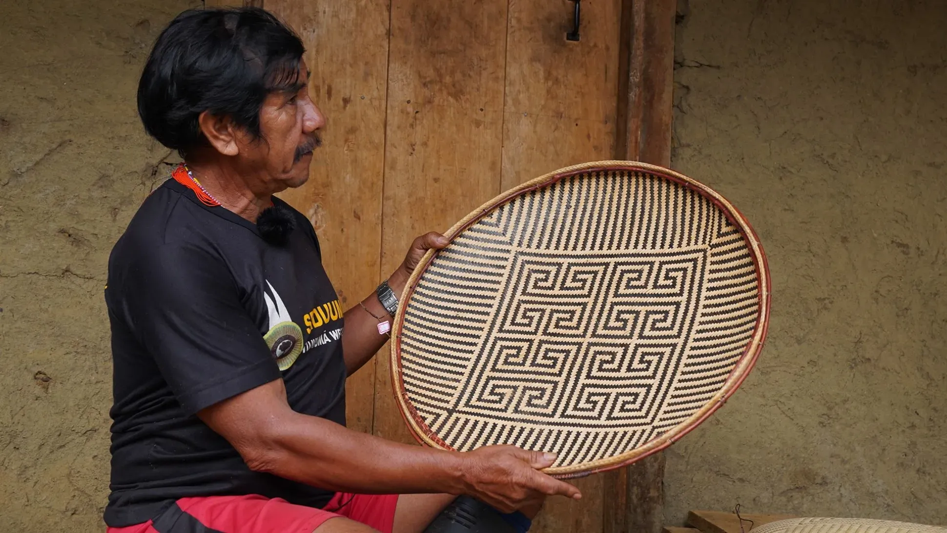 Claudio Manoel Rodrigues explaining the design of the waja tömenaato (designed) basket 