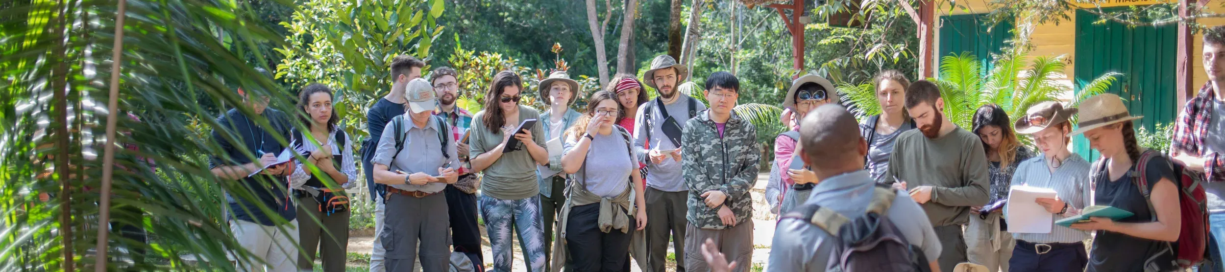 MSc students on the Madagascar fieldtrip stood in a line looking at researcher giving a talk