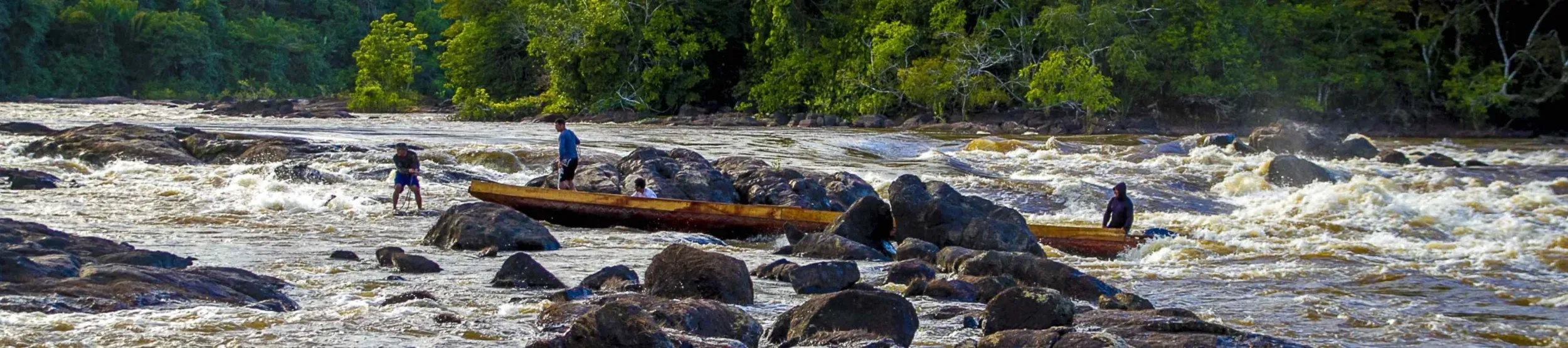 People pulling boat along river