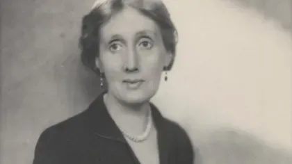 Black and white photo of Virginia Woolf taken between 1930 and 1941. She is middle aged, wearing a low cut black dress and a pearl necklace
