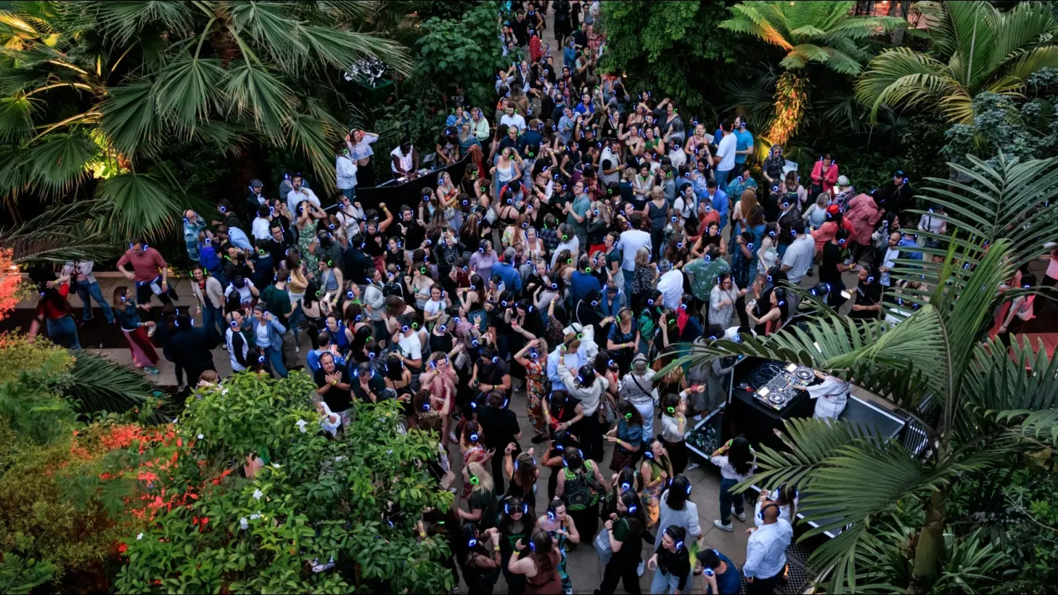 A large group of people dancing in the Temperate House at Kew Gardens Silent Disco