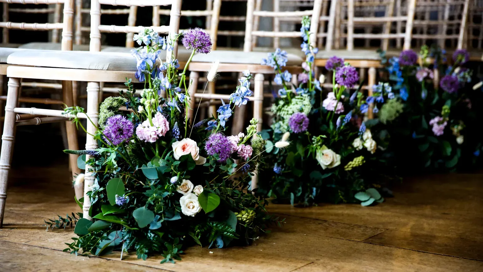 Pastel purple and white flowers on the end of aisles
