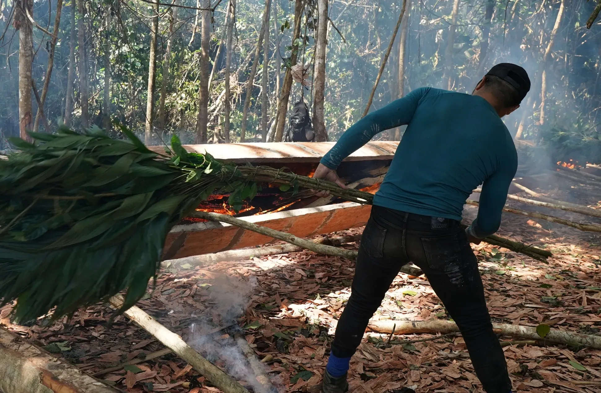 Burning the excavated tree of Cedrelinga cateniformis, to widen the dugout canoe.